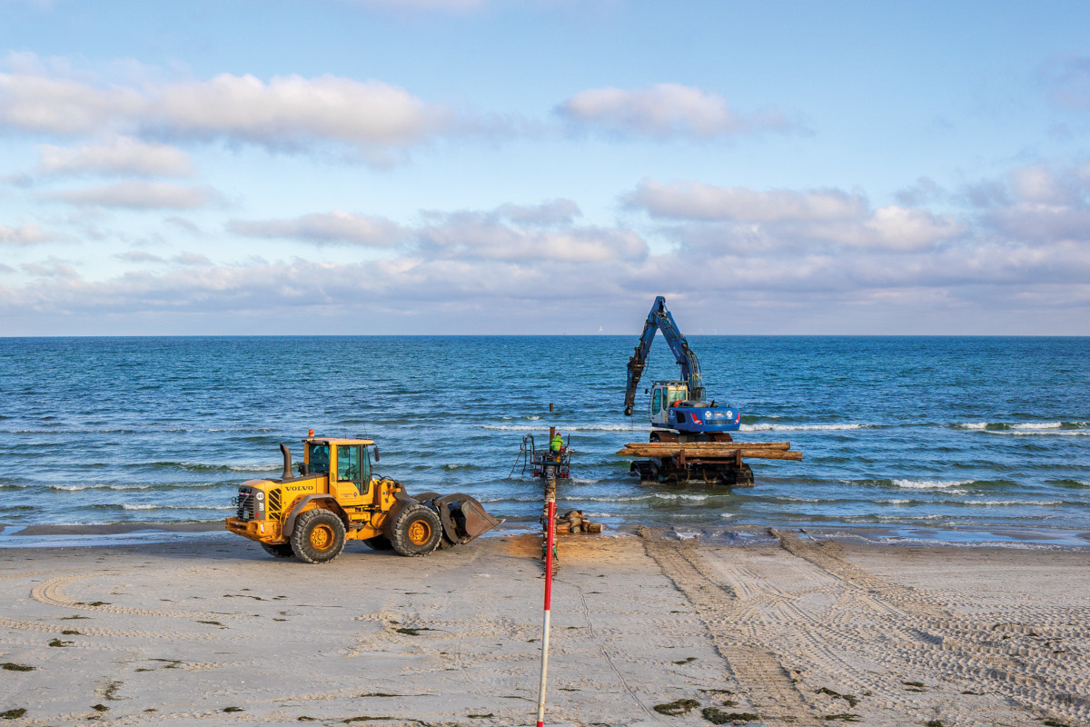 Bagger am Strand während des Buhnenbaus.