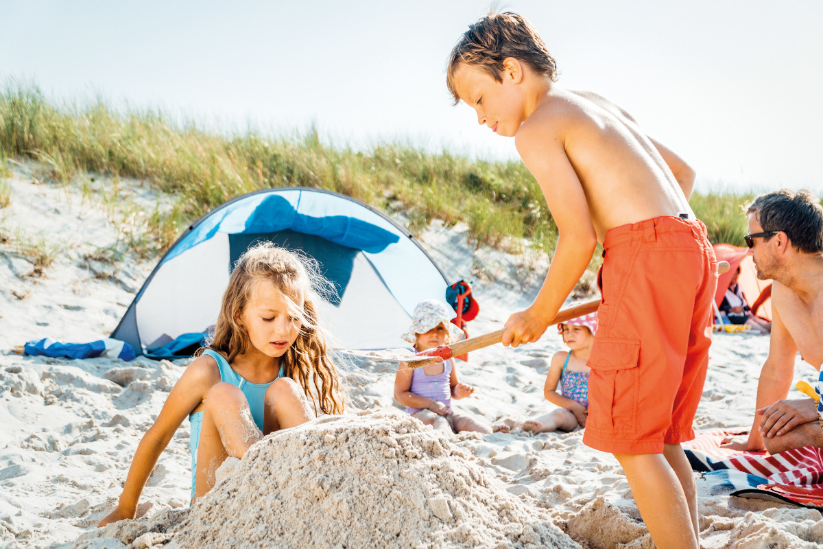 Kinder spielen am Strand.